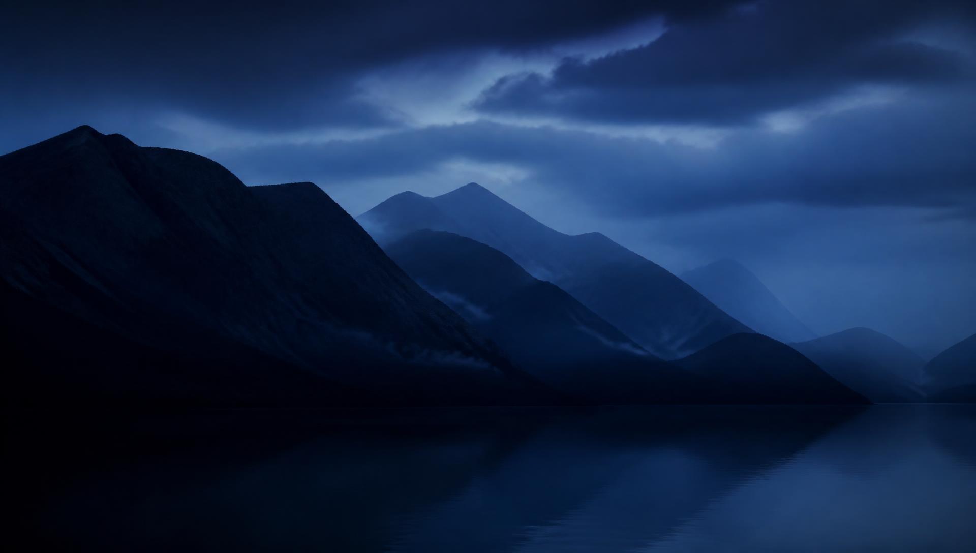 Highland ridgelines above dark water at blue hour
